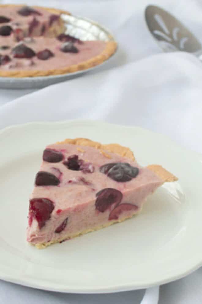 Cherry frozen yogurt pie on a white plate.
