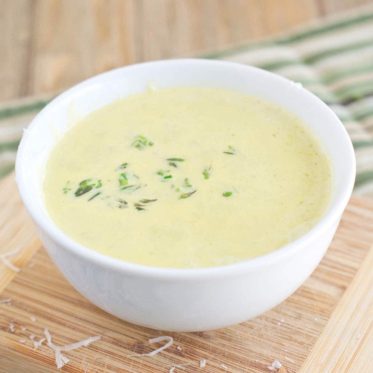 White bowl of creamy asparagus soup.