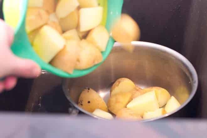 Returning potatoes to pot.
