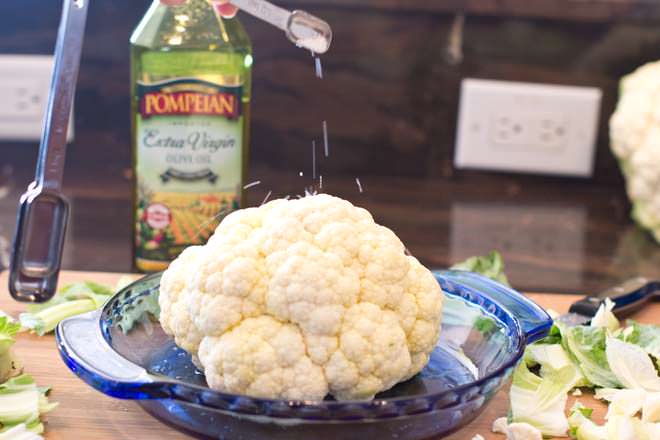 Sprinkling salt on cauliflower.
