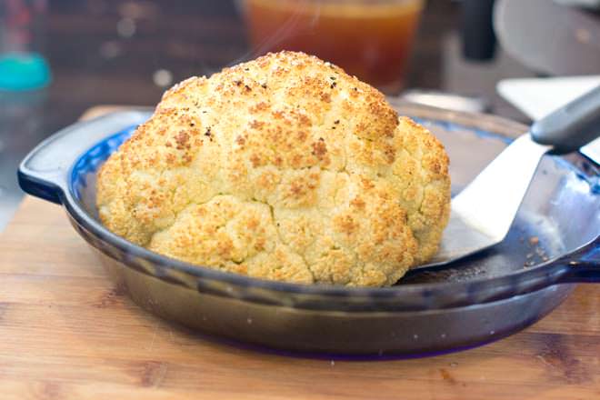Gently lift out whole roasted cauliflower with spatula.