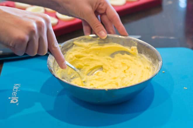 Mashing egg yolks with fork until smooth.