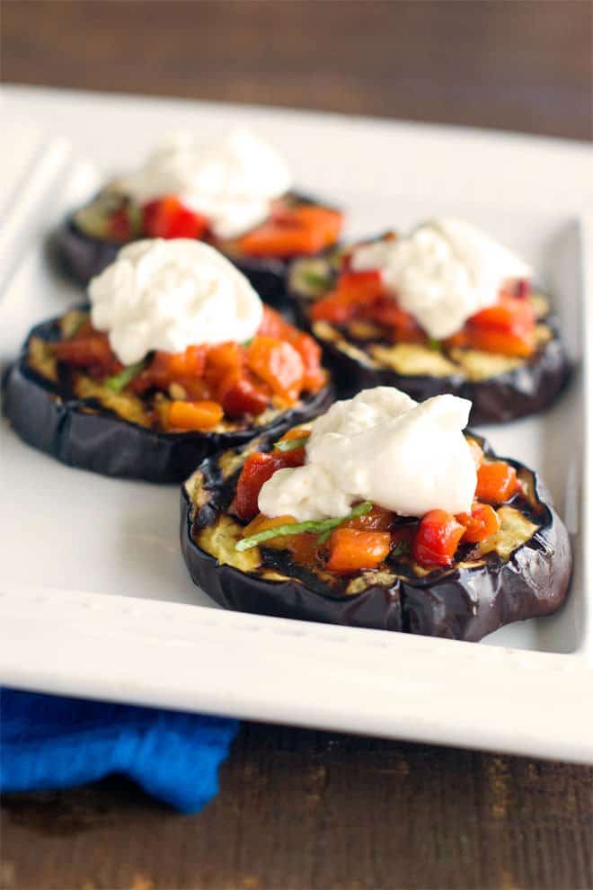 For this delicious gluten-free bruschetta recipe, grilled eggplant slices are used instead of bread. The bruschetta topping is made of roasted peppers, basil and garlic. Creamy burrata cheese makes the whole thing decadent and fabulous.