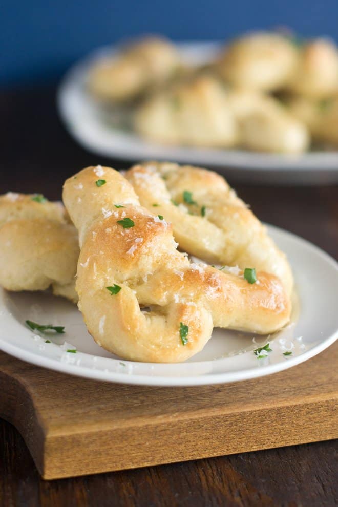 Homemade garlic knots with Parmesan and parsley on top.
