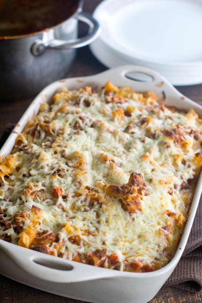 Cheese covered baked ziti in a casserole dish.