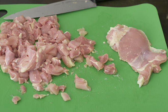 Cut up raw chicken.