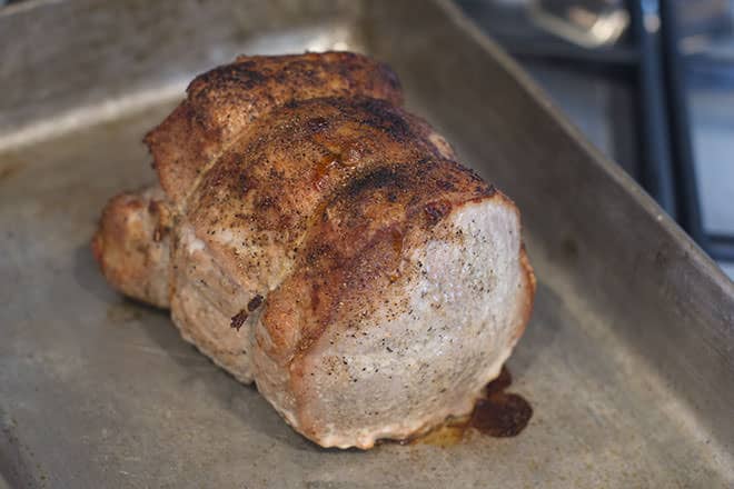 Cooked pork loin in a pan.