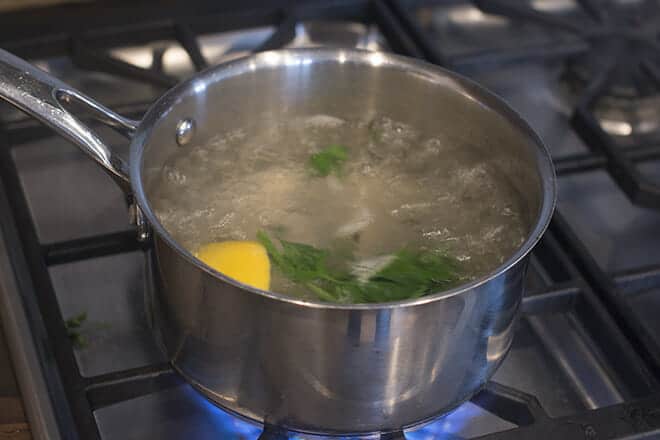Boiling water with aromatics on stove.
