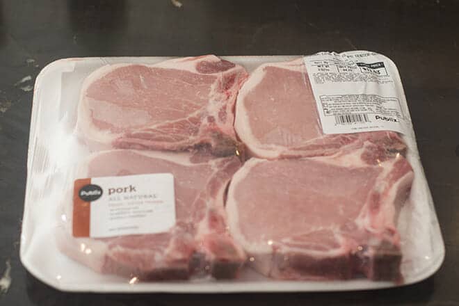 Package of four raw bone-in pork chops.