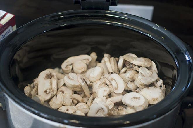 Sliced mushrooms in a slow cooker.