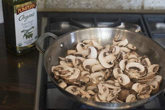 Cremini mushrooms being sauteed on the stove.