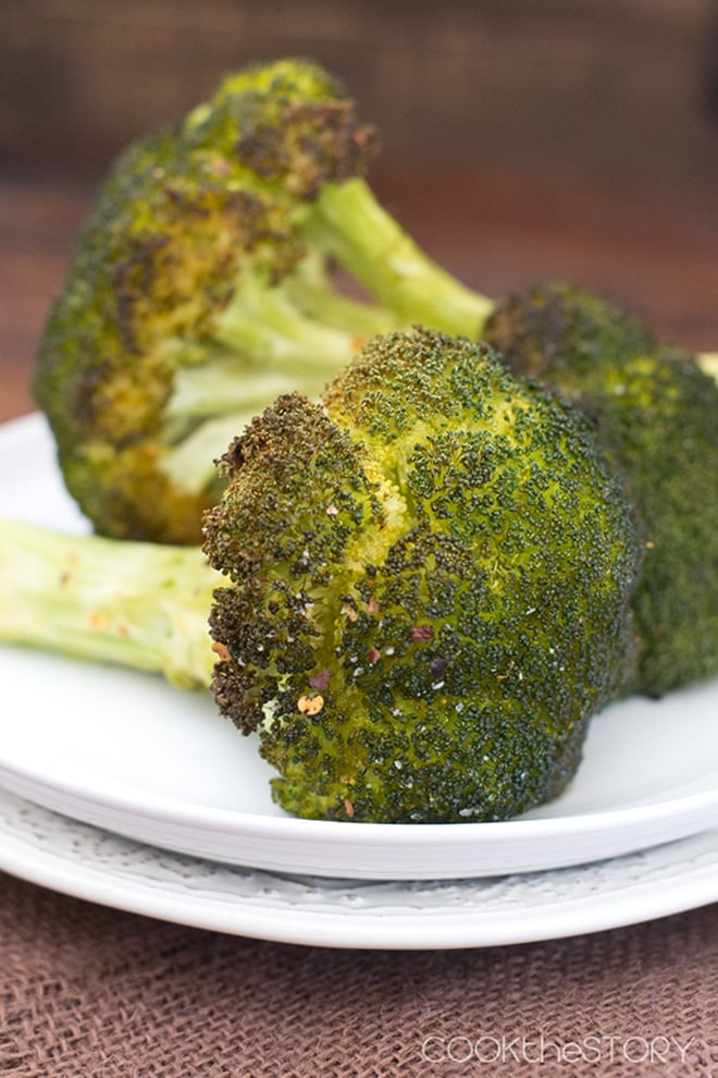 Whole Roasted Broccoli stalks on a white plate.