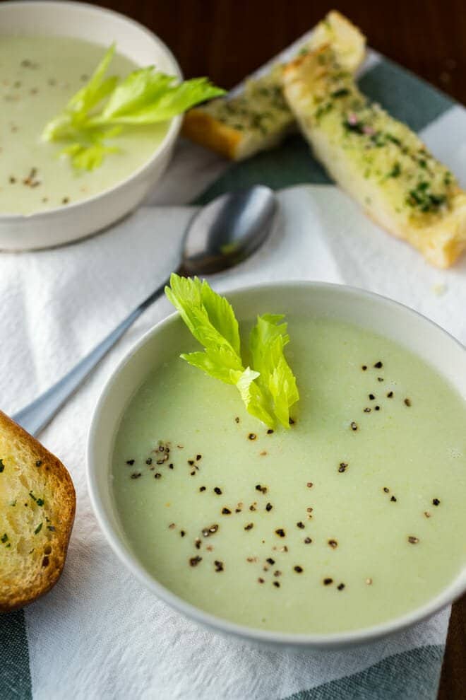 White bowl with creamy celery soup.