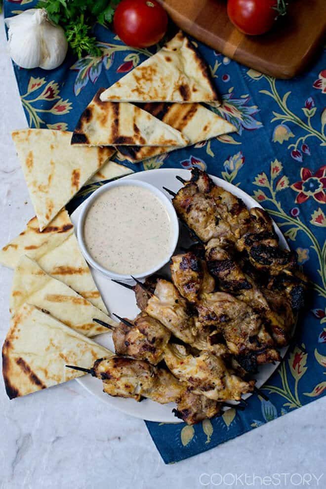 Grilled chicken kebabs with a yogurt sauce and grilled pita wedges.