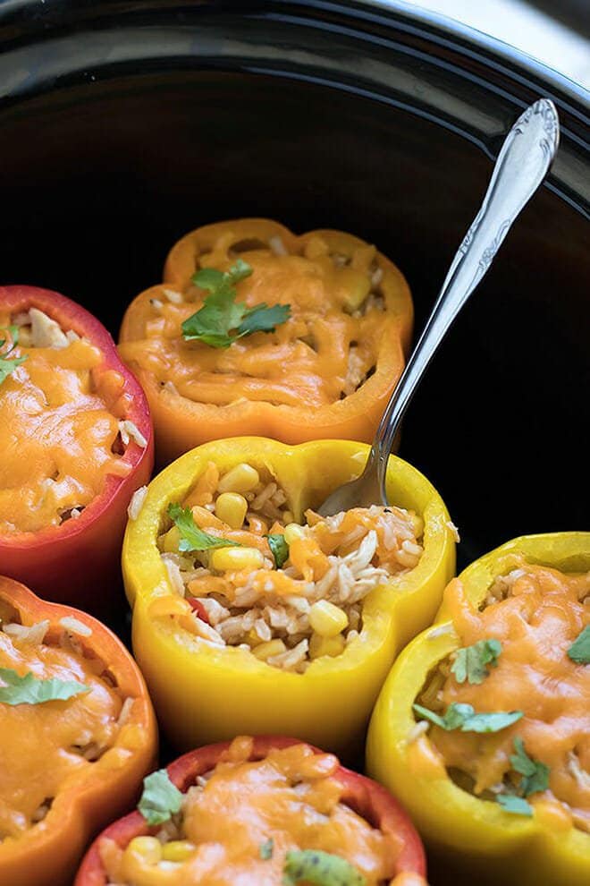 Stuffed bell peppers with rice, chicken, and cheese in a slow cooker.