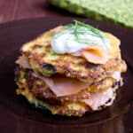 a stack of crispy browned millet pancakes topped with smoked salmon and dill