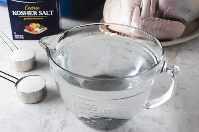 Large glass measuring cup with brine.