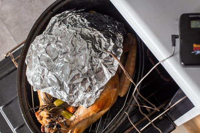 Browned turkey with foil shield and temperature probe.