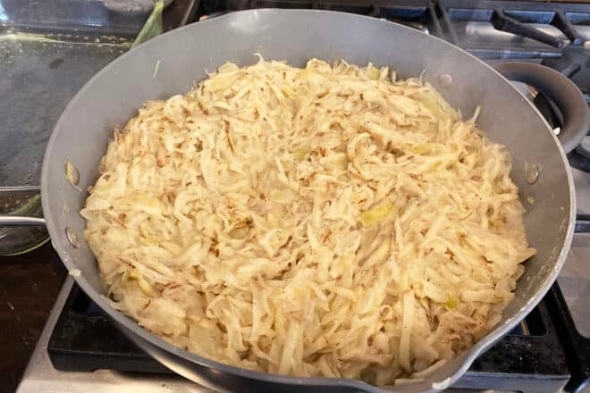 Uncooked shredded potatoes in white sauce with onions