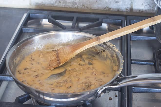 Gravy base on stove with wooden spoon.