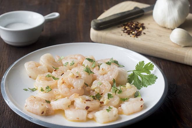 Shrimp cooked with butter and garlic on a white plate.