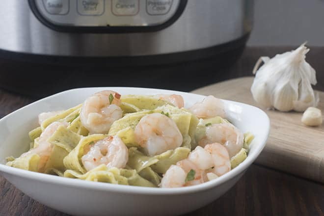 Shrimp and pasta in a white bowl.