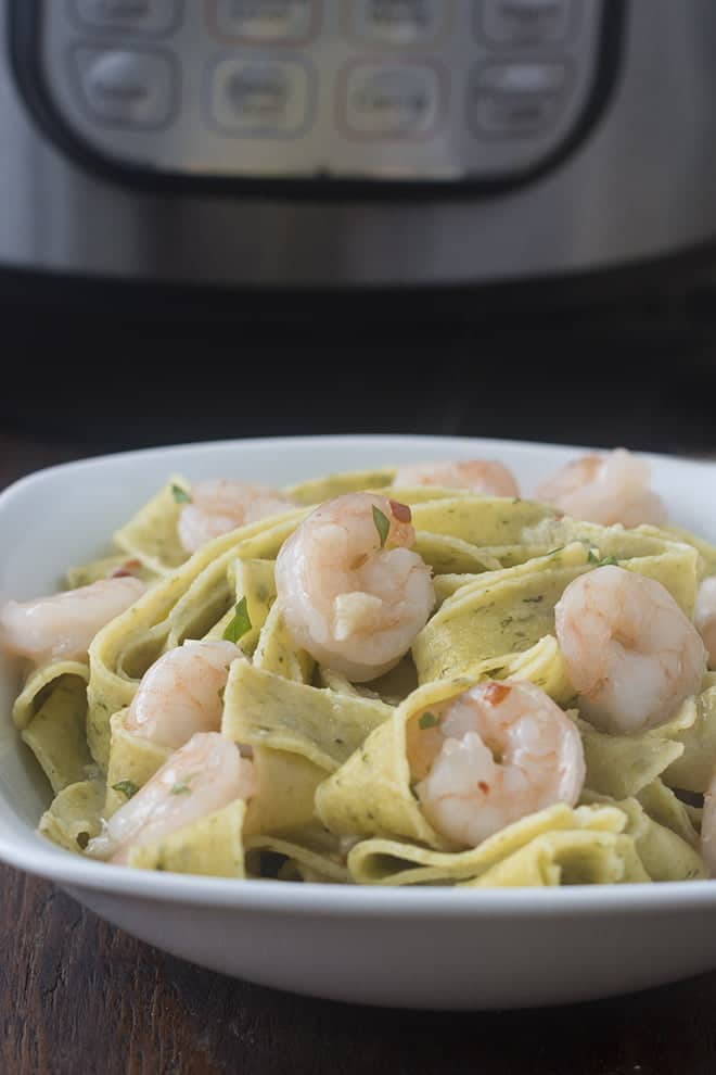 Shrimp and pasta in a white dish.