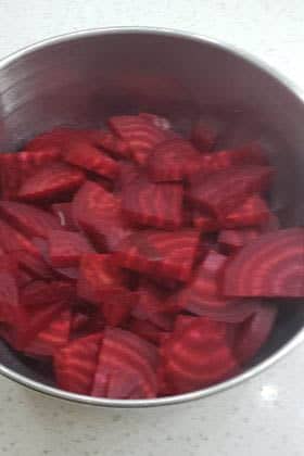 Sliced cooked beets in bowl.