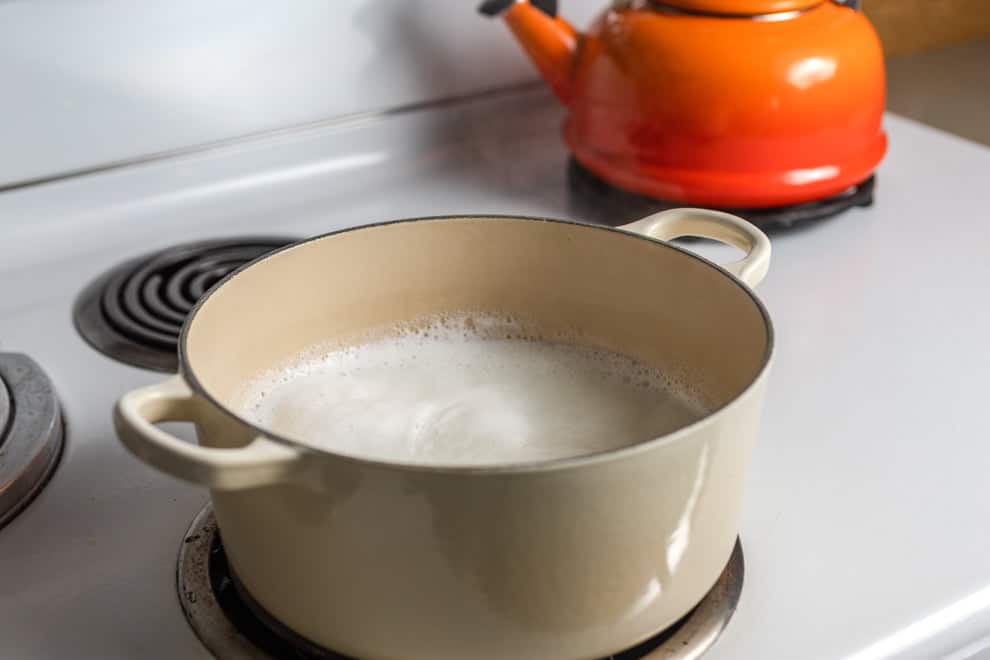 Pot of boiling water and milk on the stovetop.