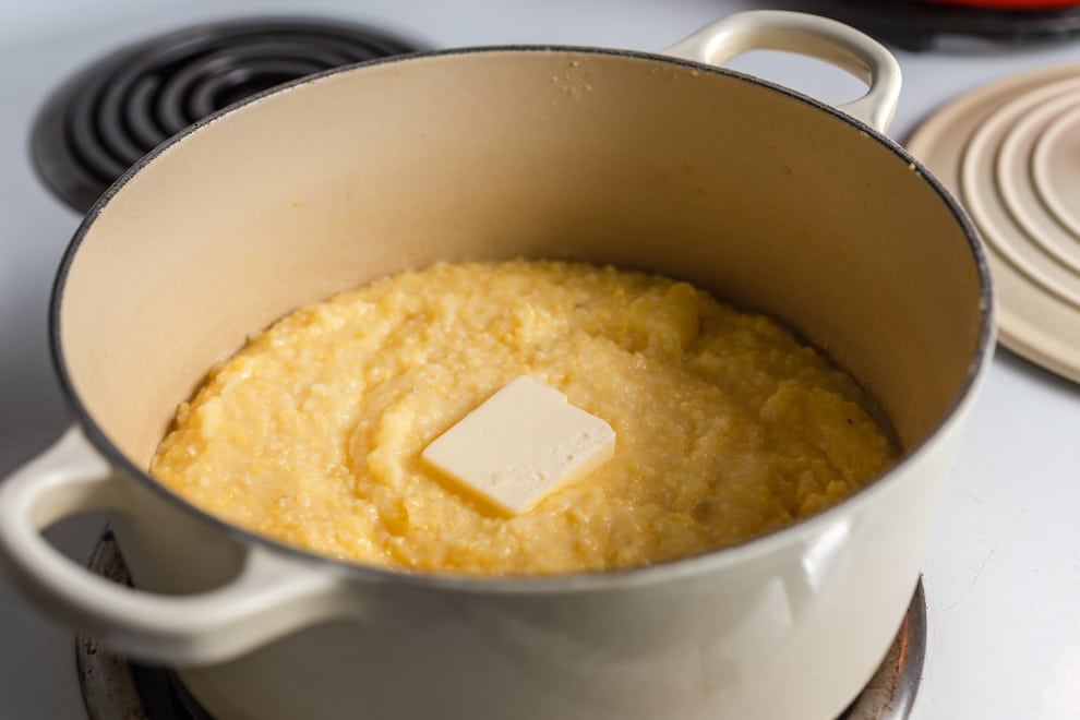 Grits in pot with butter on top.
