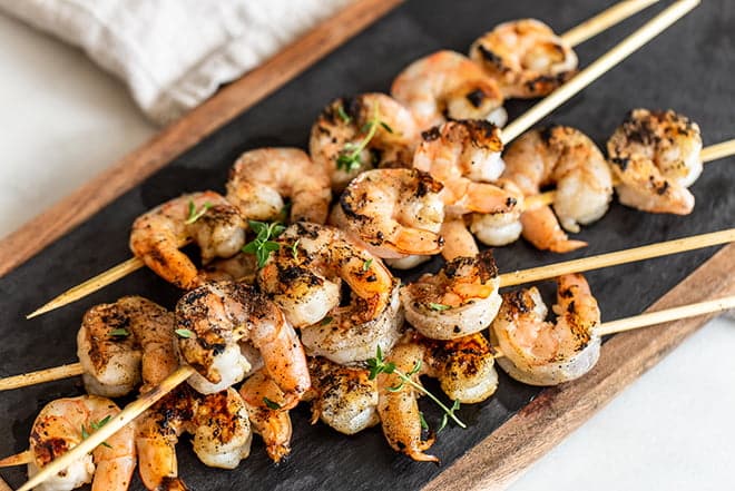 Grilled shrimp on wooden skewers.