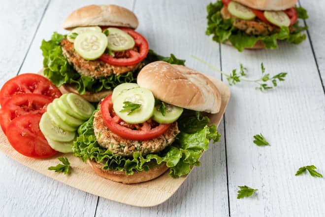 Salmon Burgers with lettuce, tomato, and cucumber.