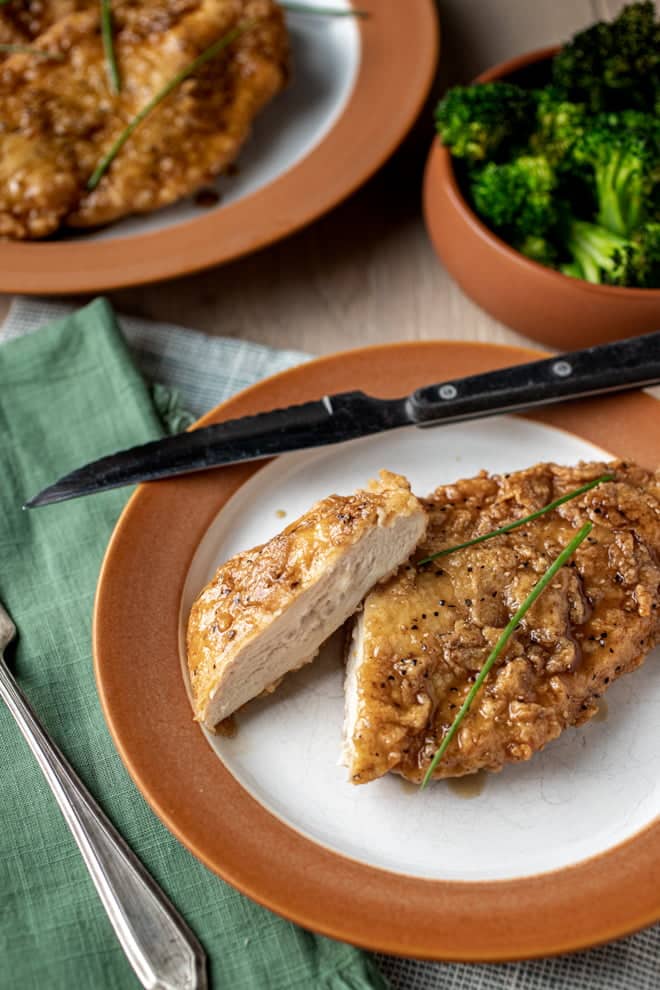 Double Crunch Honey Garlic Chicken Breast on a brown and white plate.