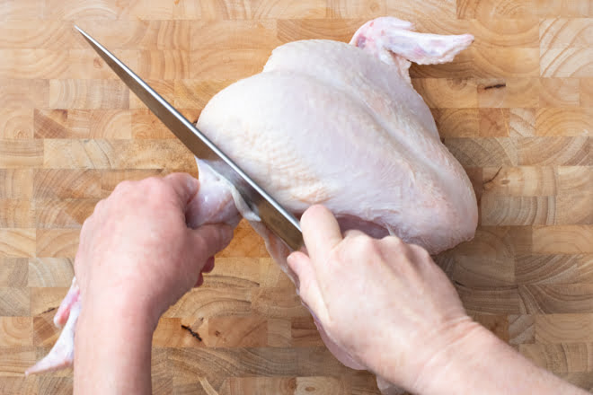 Cut into joint where wing and chicken breast meet to remove wing.