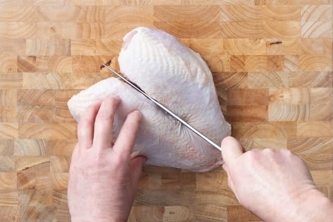 Use your knife to cut the chicken breast in half down the center line.