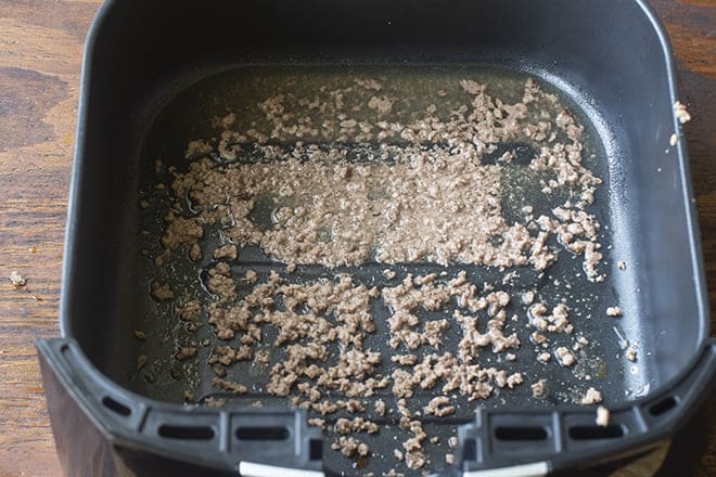 Bottom of air fryer, with fat and tiny bits of ground beef left behind.