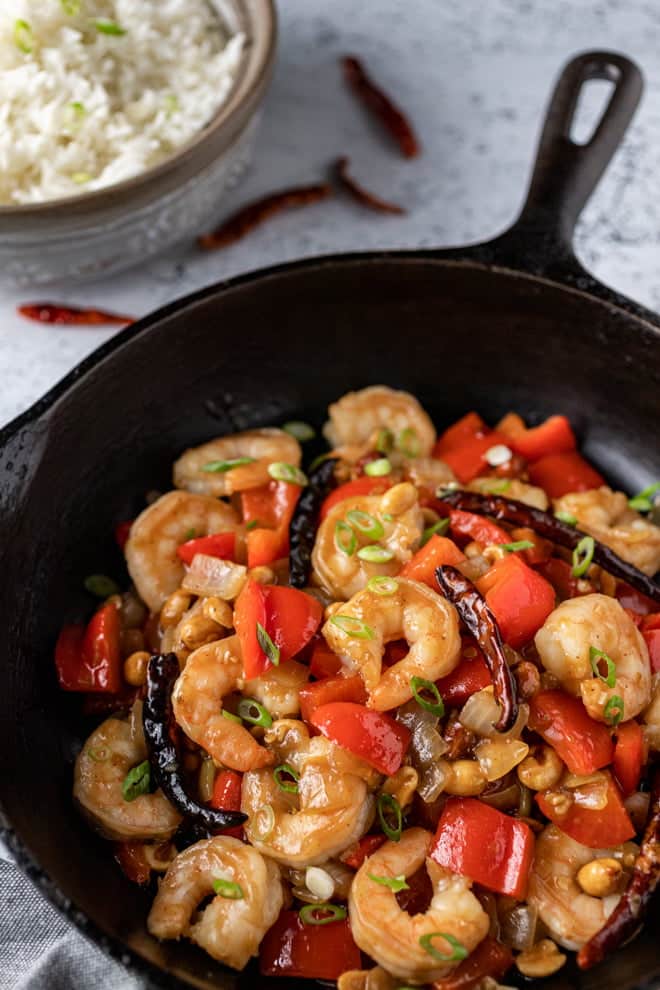 Kung Pao Shrimp with peppers and chilis in a cast iron skillet.