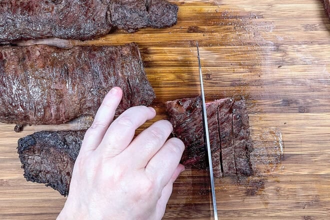 Cutting skirt steak into thin slices.