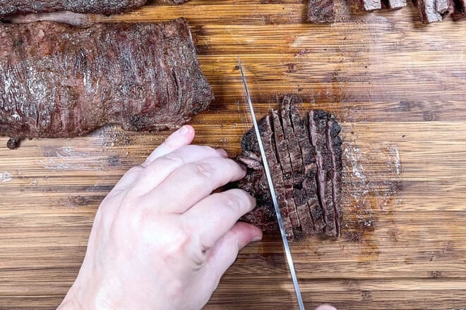 Super thin fajita slices being cut from a skirt steak.