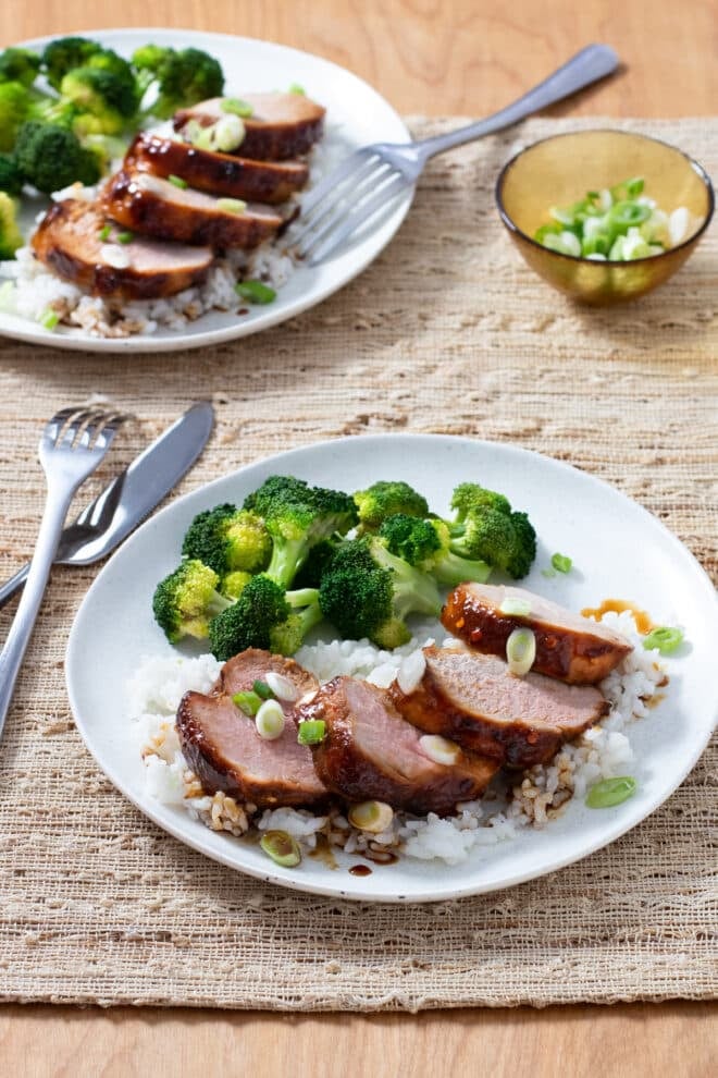 Sliced Asian Pork Tenderloin over white rice with broccoli on the side.