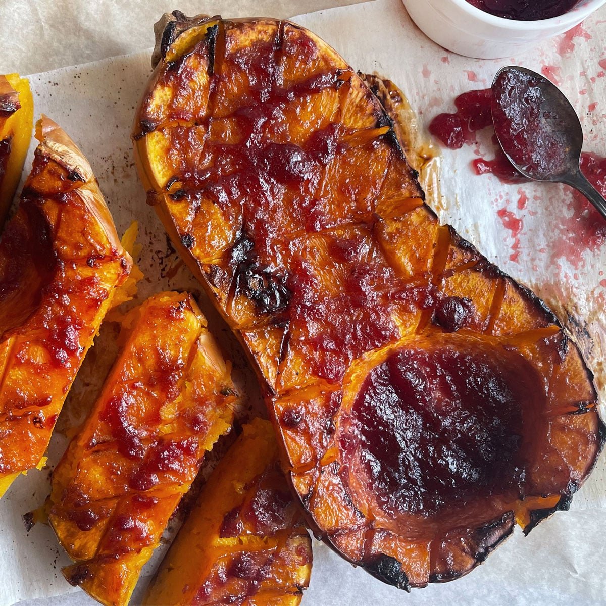 Halved butternut squash, roasted with cranberry sauce.