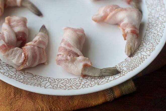 Raw bacon wrapped around frozen shrimp.