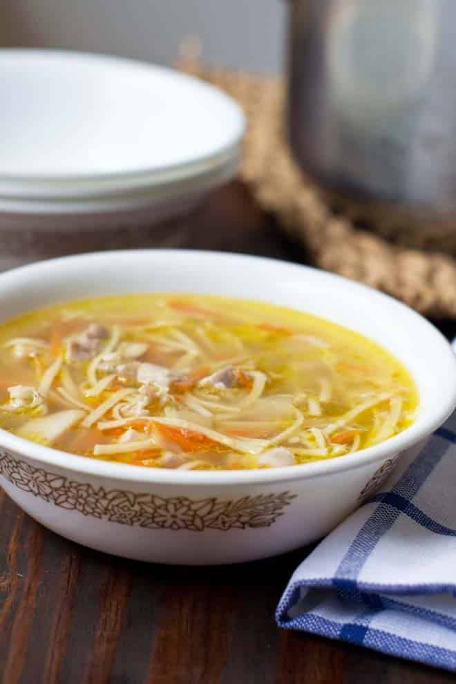 White bowl with pattern filled with easy homemade chicken noodle soup.
