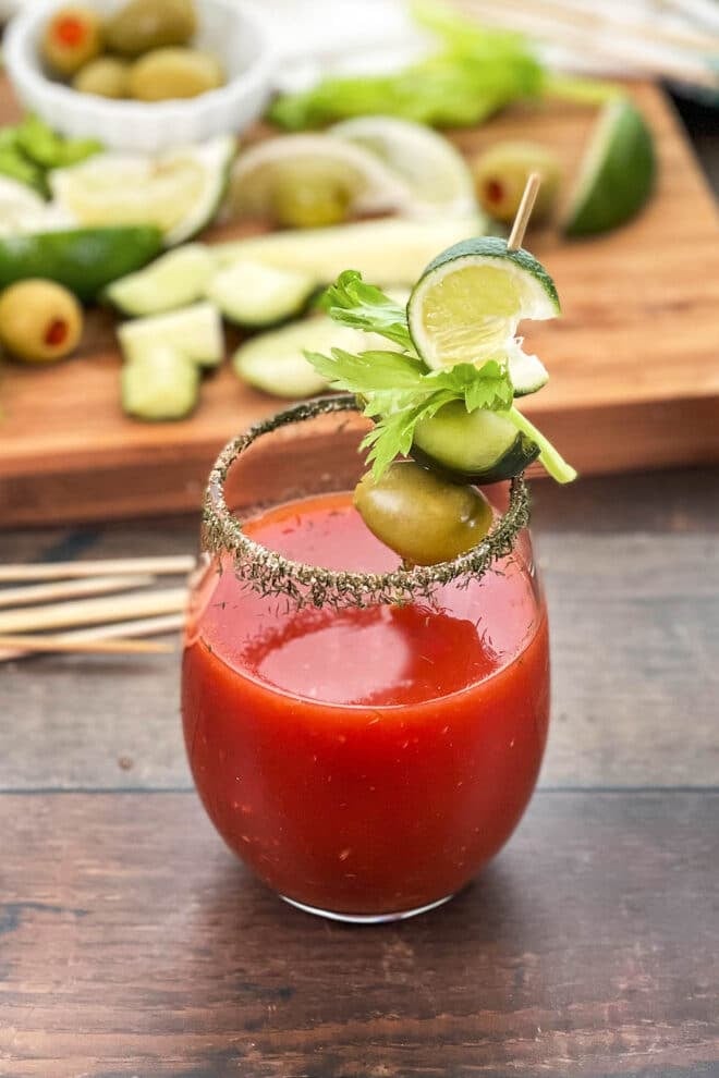 Bloody Mary with spiced rim and garnish with pickle, olive, and lime.