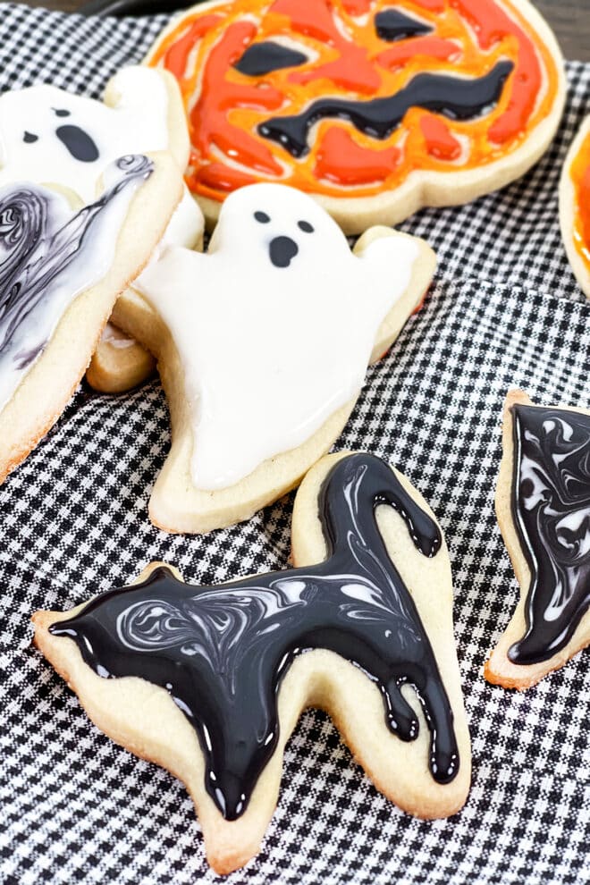 Halloween cookies decorated with royal icing - ghost, black cat, and jack o lantern.