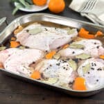 Turkey pieces in a brine in a large roasting pan.