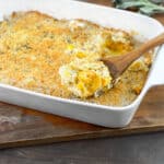 White casserole dish with butternut squash in cream sauce with breadcrumb topping.