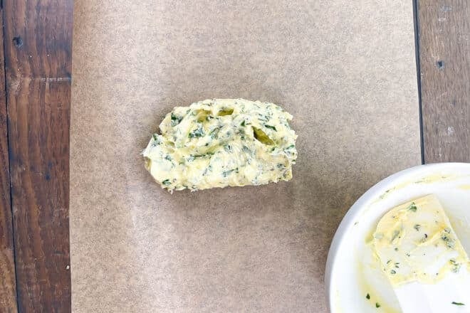 Herb butter scooped onto parchment paper.