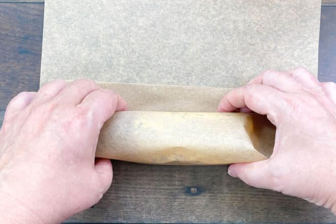 Rolling up butter in parchment paper.
