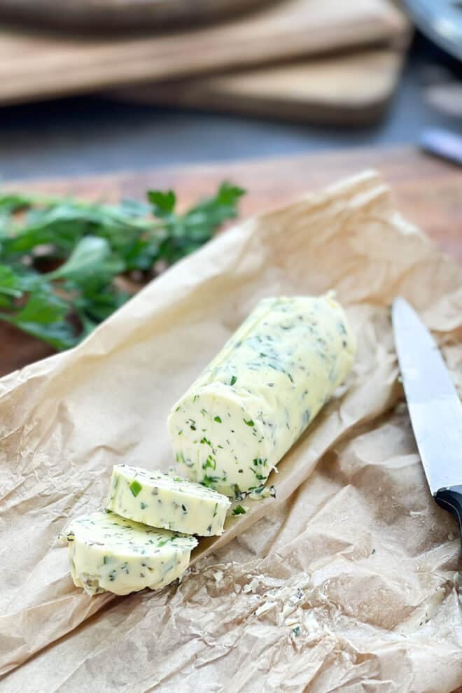Herb butter for steak in a log on parchment paper.
